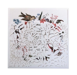 Detail of laser-cut white floral invitation card with vintage bird and flower insert