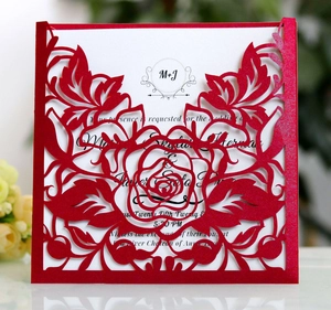 Elegant red laser cut wedding invitation with intricate rose patterns and white inner card