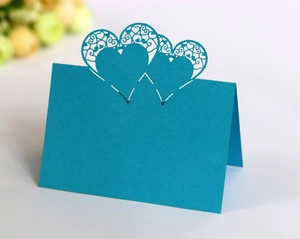Detailed laser-cut blue place card featuring intricate hollow heart-shaped patterns