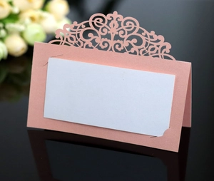 Detail of pink laser-cut wedding place card with pearlescent finish and white insert