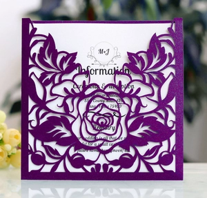 Detail of laser-cut purple glitter wedding invitation with intricate rose flower hollow patterns