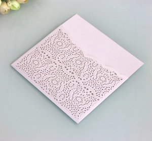 Close-up of laser-cut lace wedding invitation with intricate floral hollow patterns
