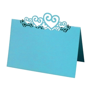 Detail of light blue laser-cut place card with heart-shaped hollow design and folding structure