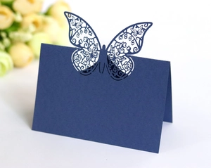 Detailed laser-cut butterfly place card in navy blue on a white background scene