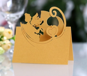 Detailed laser-cut gold angel place card with heart patterns for elegant wedding decor