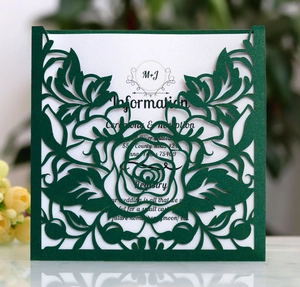Macro detail of laser-cut green floral wedding invitation with white insert card
