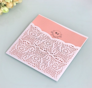 Detailed laser-cut wedding invitation set with white lace cover and pink inner card stock
