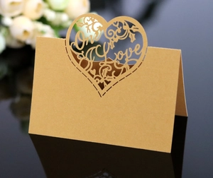 Macro shot of heart-shaped hollow seat card with One Love laser cut design on kraft paper