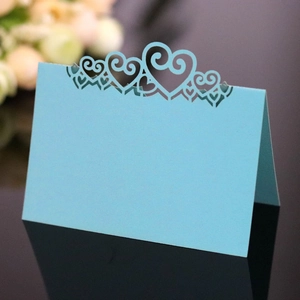 Close-up of light blue laser-cut heart seat card for wedding and party table settings