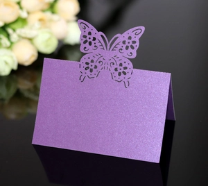 Macro detail of laser-cut butterfly place card in purple pearlescent paper with shimmer