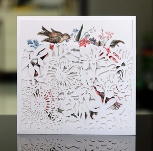 Detailed laser-cut floral pattern on elegant wedding invitation with vintage bird design