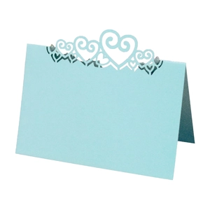 Detail of light blue laser-cut place card featuring intricate hollow heart-shaped designs