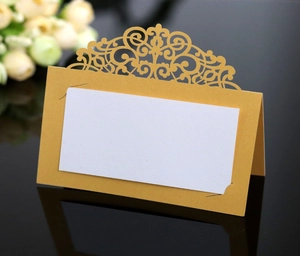 Detail of laser-cut lace wedding place card with gold pearlescent hollow design