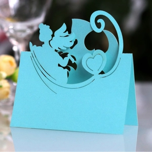 Detail of laser cut light blue place card featuring angel and heart motifs for table decor