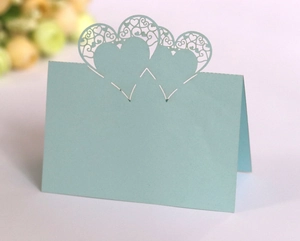 Detailed laser cut heart hollow place cards in light blue pearlescent paper for wedding table