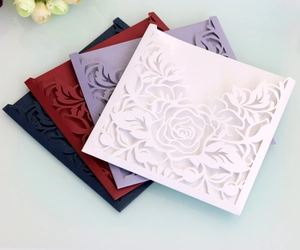 Detailed laser cut rose patterns on elegant wedding invitation card covers in four colors