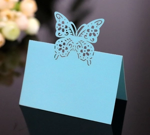 Detailed laser-cut blue butterfly wedding place card with elegant floral hollow patterns