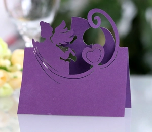 Macro shot of purple laser cut wedding place card with Cupid heart hollow design