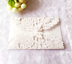 Detailed laser-cut white wedding envelope featuring intricate floral and butterfly patterns