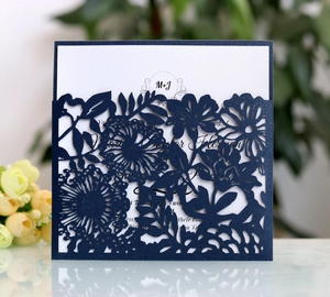 Elegant navy blue laser-cut floral invitation with white card and pearlescent finish