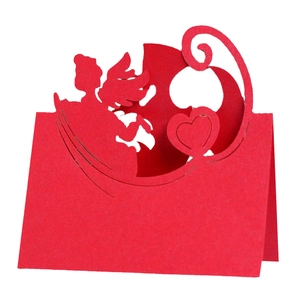 Detail of red laser cut wedding table card with 3D cupid and heart hollow pattern