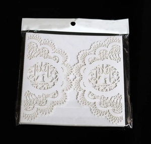 Detailed laser-cut wedding invitation featuring elegant white lace birds and branch design