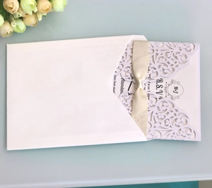Elegante lasergeschnittene Hochzeitseinladung mit cremefarbener Satinschleife und Umschlag