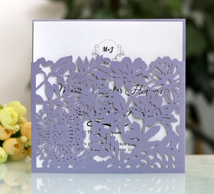 Macro view of laser-cut purple floral wedding invitation with white insert card