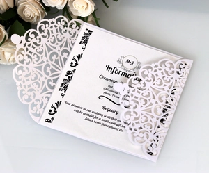 Detail einer lasergeschnittenen Hochzeitseinladung mit bedruckter Karte und weißen Rosen