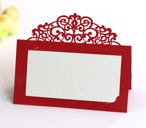 Detail of red laser-cut lace table card with white insert for wedding seating