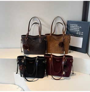 Detail of four matte leather tote bags in various colors with bead charms and gold hardware