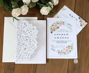Macro detail of laser-cut rose patterns on elegant white wedding invitation sleeve