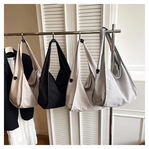 Row of large minimalist canvas hobo bags in cream, black, oat, and grey colors