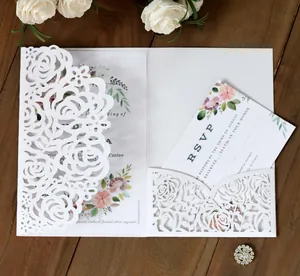 Detail of laser-cut rose hollow pocket and elegant floral wedding invitation on wood
