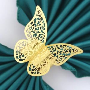 Detailed laser-cut golden butterfly napkin ring with intricate floral scroll patterns
