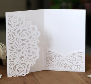 Elegant white laser-cut rose wedding invitation with intricate floral lace and pocket