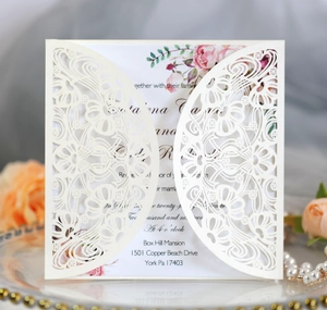 Detailed close-up of ivory laser-cut wedding invitation card with pink rose floral inner card