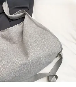 Close-up of light grey shoulder bag featuring fine fabric texture and soft woven edges