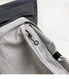 Close-up of smooth metal zipper and textured gray fabric on minimalist tote bag