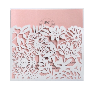 Macro detail of laser-cut floral wedding invitation with soft pink insert card