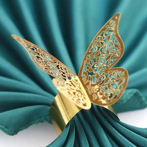 Elegant gold butterfly napkin ring with hollow laser-cut design on green silk fabric