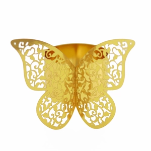 Detail of laser-cut golden butterfly napkin ring with intricate filigree vine pattern