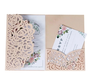 Macro view of peach pink laser-cut floral wedding invitation set with RSVP card