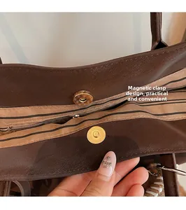 Detail of magnetic buckle closure and striped fabric lining with zipper pocket