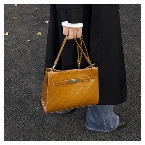 Chic brown quilted underarm bag with gold metal twist lock and thin handle detail