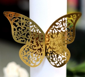 Close-up of golden laser-cut butterfly napkin ring with intricate vine hollow pattern
