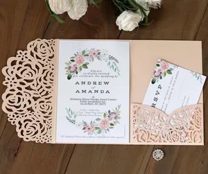 Detailed close-up of laser-cut rose patterns on elegant pink wedding invitation cards
