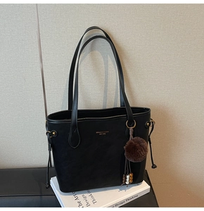Détail du sac cabas noir en similicuir avec lettrage doré et charm en peluche marron