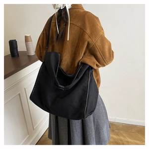 Detailed view of the large black slouchy tote bag shown on model for size and scale
