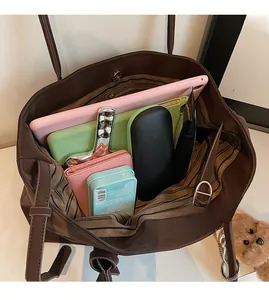 Interior view of spacious brown suede tote bag showing large storage capacity and striped lining